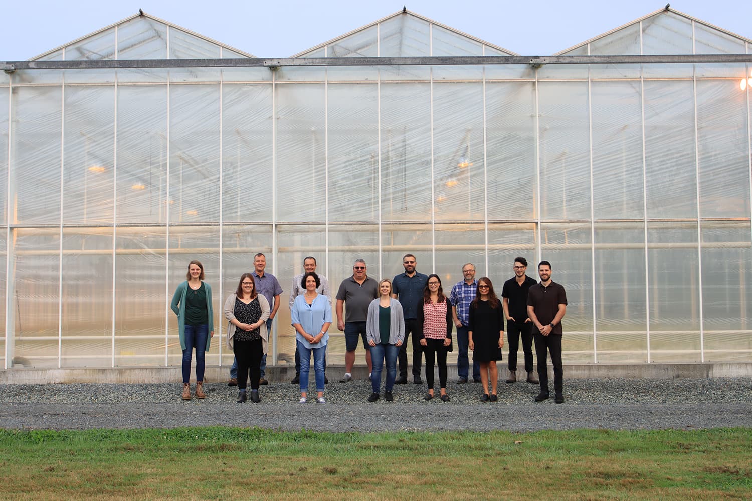 Bevo Farms team members standing together in front of a greenhouse
